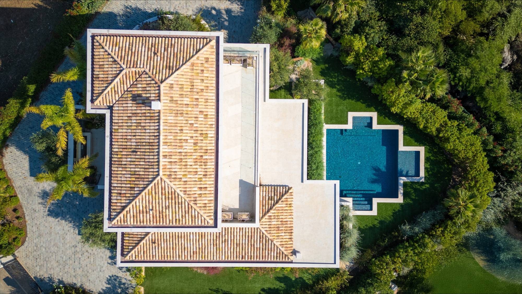 Villa contemporaine aux toits de tuiles et piscine en croix, vue zénithale