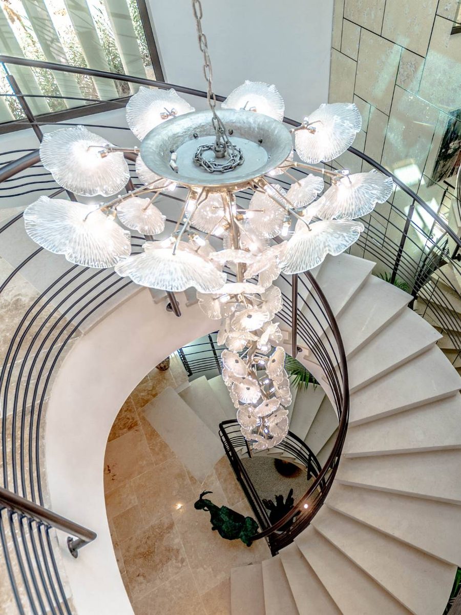 Spiral stone staircase beneath a blown-glass chandelier