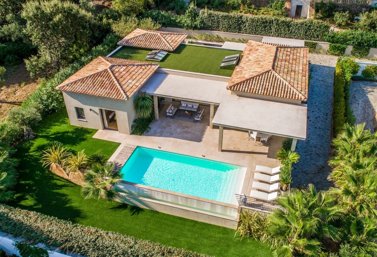 Villa with tiled roofs and an infinity pool, aerial view