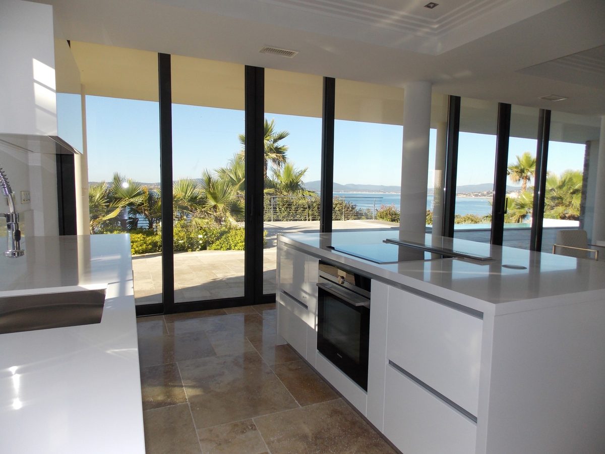 White kitchen opening onto the sea